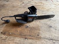 Full view of Remington electric chainsaw showing black body, power cord, and 12 inch cutting bar with chain.