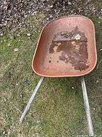 Top view showing rusted inside of the metal tray with dirt, leaves, and wear.