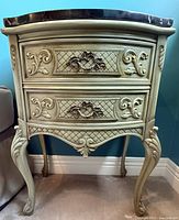 Front view of painted wood bedside table showing two drawers and marble top
