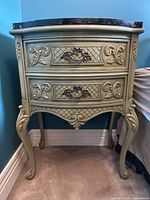 Full front view of bedside table showing overall shape, finish, marble top and drawer fronts