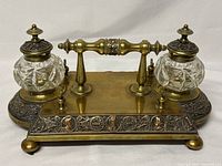 Front view of brass and copper desk set with inkwell lids closed