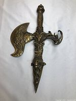 Full view of brass ceremonial dagger showing handle, crossguard and blade