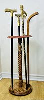 Four canes displayed in wooden stand
