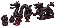 Lot comprising a red dragon statue and six matching laughing Buddha statues arranged together showing size scale and finish.