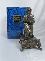 Front and side view of figurine with original blue decorative box behind it showing branding Studio Collection by Veronese Design Studio.