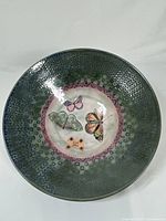 Top view of ceramic decor bowl showing butterfly artwork and outer geometric rim design.