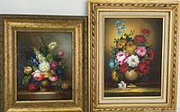 Two framed floral oil paintings side by side in gold wooden frames