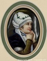 Close-up view of the hand-painted oval porcelain portrait showing the young woman in prayer with white hood and green leaf decoration.