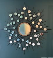 Full front view of large brass starburst decorative mirror on wall.