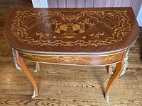 Top-down view showing demilune shape and floral marquetry inlay pattern on veneer surface