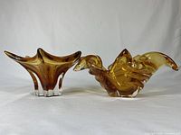 Front side view of two amber colored glass bowls, one star-shaped, one organic shape