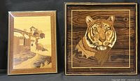 Photo showing two framed pieces of vintage inlaid wood marquetry art: a rectangular Italian landscape scene and a square tiger portrait.