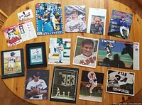 Table display of 15 Nolan Ryan memorabilia items including magazines, framed prints, glossy photographs, postcards, and catalogs.