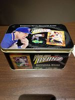 Metal tin with Nolan Ryan graphics and branding on the lid and sides