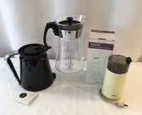 Photo showing all four items: Pyrex carafe, boxed FOMO milk frother, Keurig K-Carafe, and Braun coffee grinder
