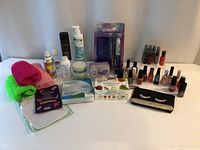 Full display of all items including hair straightener in original packaging, soaps, shower cloths, nail polishes, and other toiletries on white surface.
