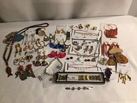Full collection of assorted jewelry including earrings, necklaces, rings, wristbands, and clips arranged on a flat surface
