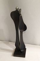 Front view of the abstract steel sculpture showing two elongated human figures close together