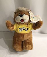 Full front view of vintage Zellers Zeddy bear plush with yellow shirt and original tag attached.