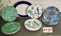 Overview of all pieces: stacks of three patterned dinner plates and one blue-rim platter