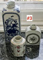 Three-piece group shot showing tall blue and white vase at back left, rectangular tea jar at back right, hexagonal tea jar in front