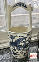 Front view of vase showing phoenix motif and top of basket handle with blue decoration