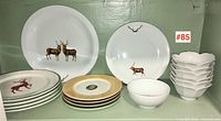 Two large deer motif dinner plates at back, assorted smaller plates and bowls front