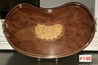 Full view of wooden serving tray showing overall shape, finish, brass handles and central inlaid design
