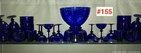Overall display of assorted cobalt blue glassware on shelf