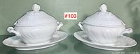 Pair of white porcelain covered sauce dishes with underplates displayed front view