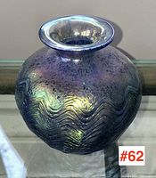 Front view of iridescent art glass vase showing flared lip and textured wave pattern.