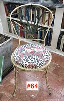 Front view showing the wrought iron frame, decorative leaf and cattail backrest, and patterned upholstered seat.
