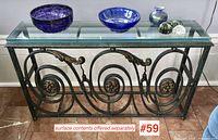 Full front view of wrought iron console table with glass top on marble floor