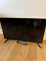 Front view of the 33 inch Westinghouse TV showing the screen and remote in front.