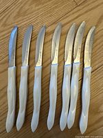 Seven utensils laid on wooden floor showing full set