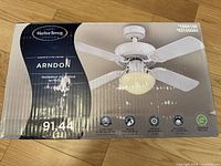 Front of original box showing Harbor Breeze Arndon ceiling fan image and key features like reversible blades, integrated light, and motor specs.