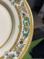 Close-up of plate edge showing detailed gold and colored floral decoration