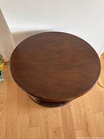 Top view of round wooden side table showing smooth tabletop surface.