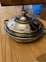 Silver serving dish with domed lid, beaded trim and finial knob