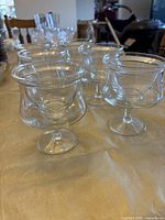 Set of six vintage shrimp cocktail glasses shown with liners inside on table.