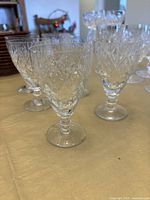 Six Waterford crystal drinking glasses showing cut crystal faceted design and short ringed stems.