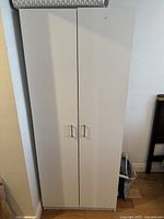 Closed white wardrobe showing exterior with two doors and handles.