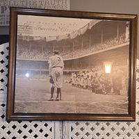 Full framed poster showing Babe Ruth on baseball field with crowd behind, sepia-tone.