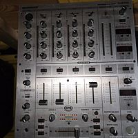 Top view of Behringer DJX700 mixer showing channel knobs, EQ controls and faders