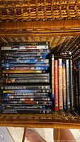 Top view of 22 DVDs and Blu-ray discs in a woven basket showing titles and cases