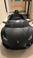 Front angle of the black kids ride-on Lamborghini car showing detailed bodywork and Lamborghini badge on hood.