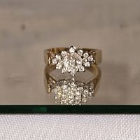 Top view of diamond cluster ring on reflective surface