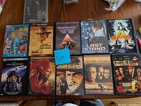 Photo of 11 DVDs laid out on wood surface, identifying movies included.