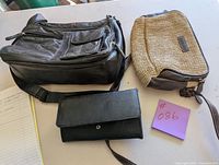 Photo showing all three items: black leather purse, beige woven purse with dark brown accents, and black wallet with snap closure.