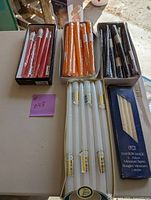 Top view of all five boxes of candles on table showing array of colors and quantity in each box.